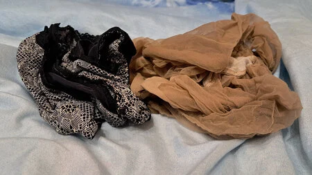 Man wearing transparent suntan pantyhose teasing with his legs on the bed