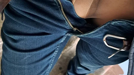 Man posing in women's pantyhose under jeans outdoor